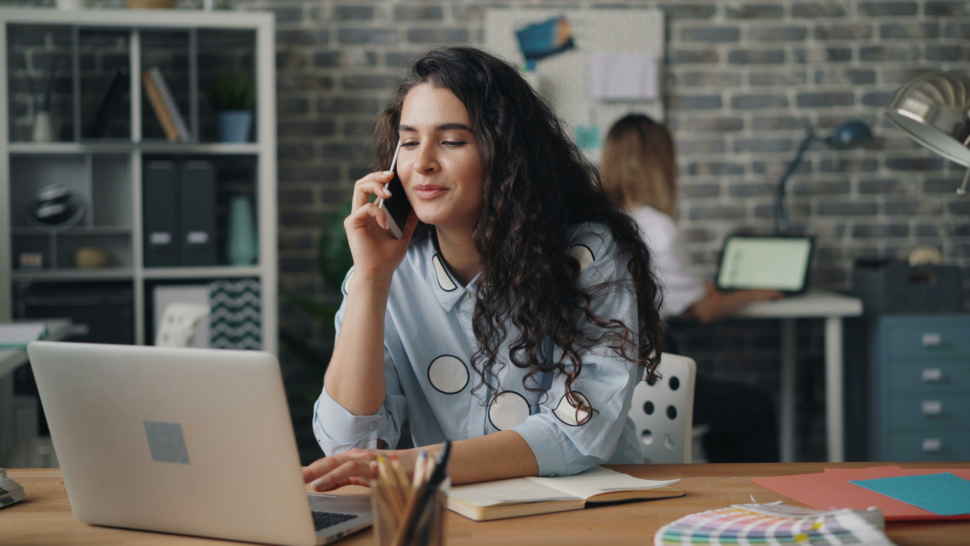 Woman talking on phone and helping customers.