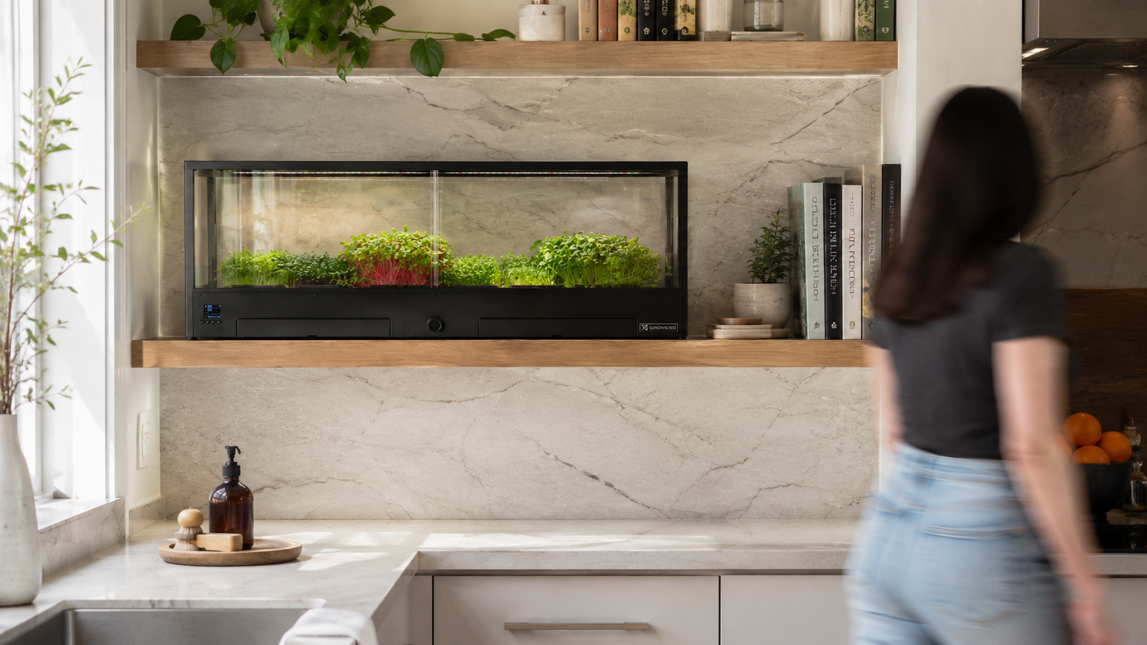 Modern kitchen with a woman walking by, featuring a Minigro, indoor microfarm