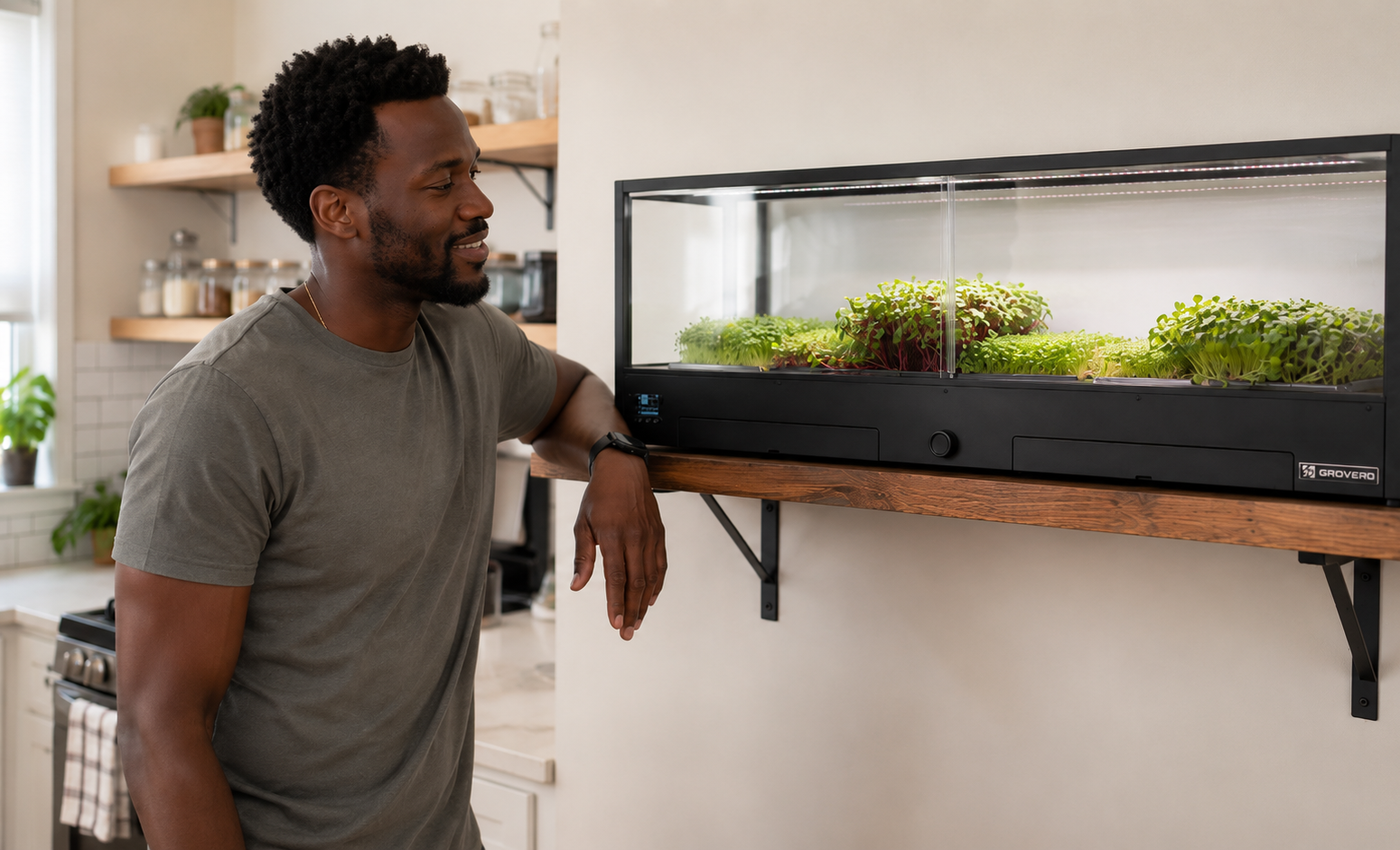 Home cook standing in front of MiniGro, an indoor microfarm, sitting on a wall mounted shelf.