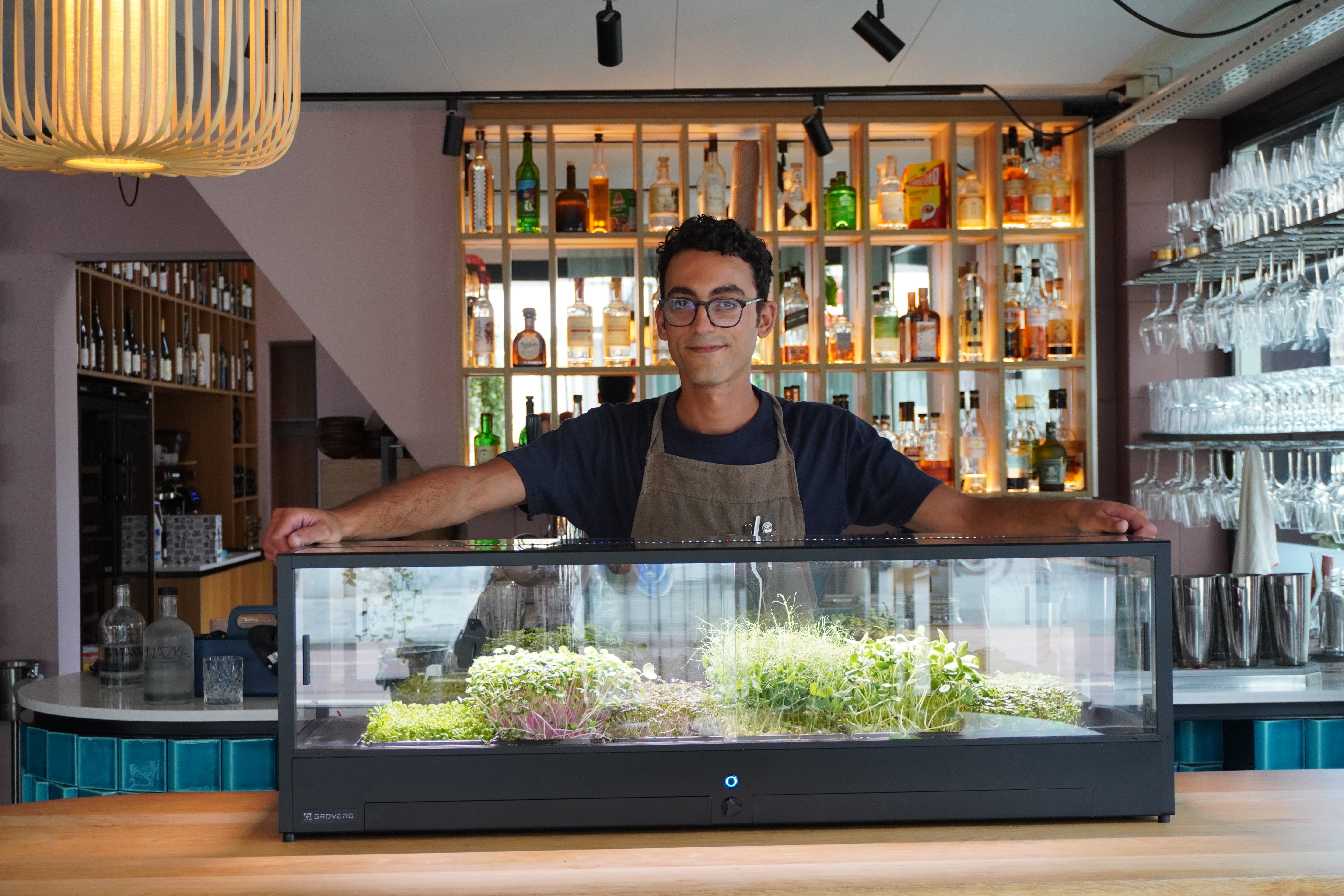 Man standing behind Minigro, a microfarm to grow greens.